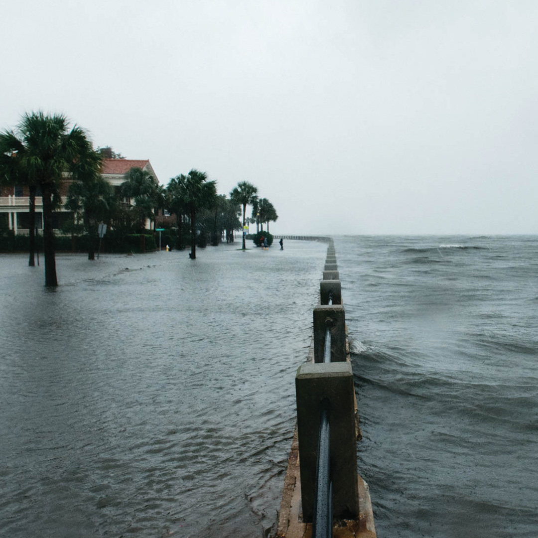 Water flooding either side of a barrier in a residential neighborhood in Charleston, South Carolina.