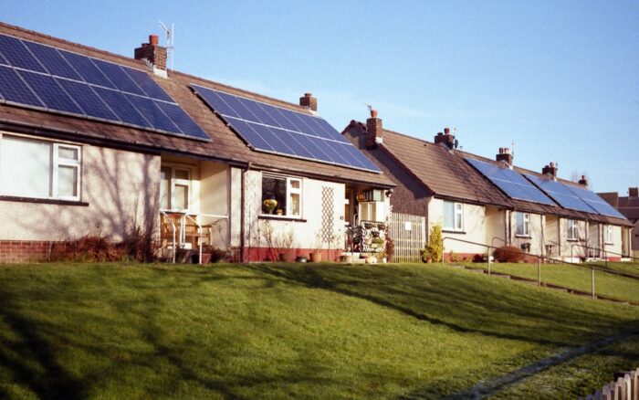A row of attached single family homes have rooftop solar panels.